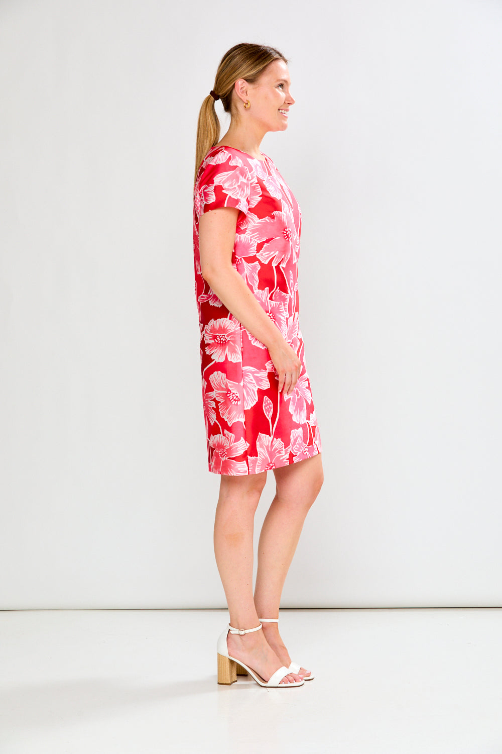 Woman wearing a pink floral dress against a white background