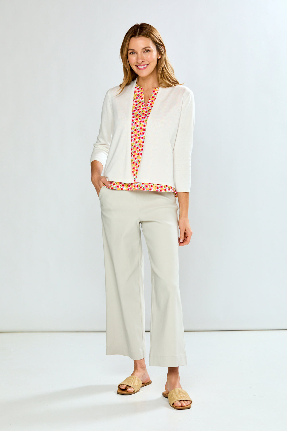 Woman wearing a white outfit with a red patterned top against a white background