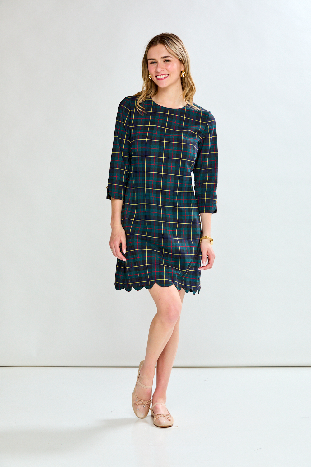 Woman wearing a plaid dress against a white background