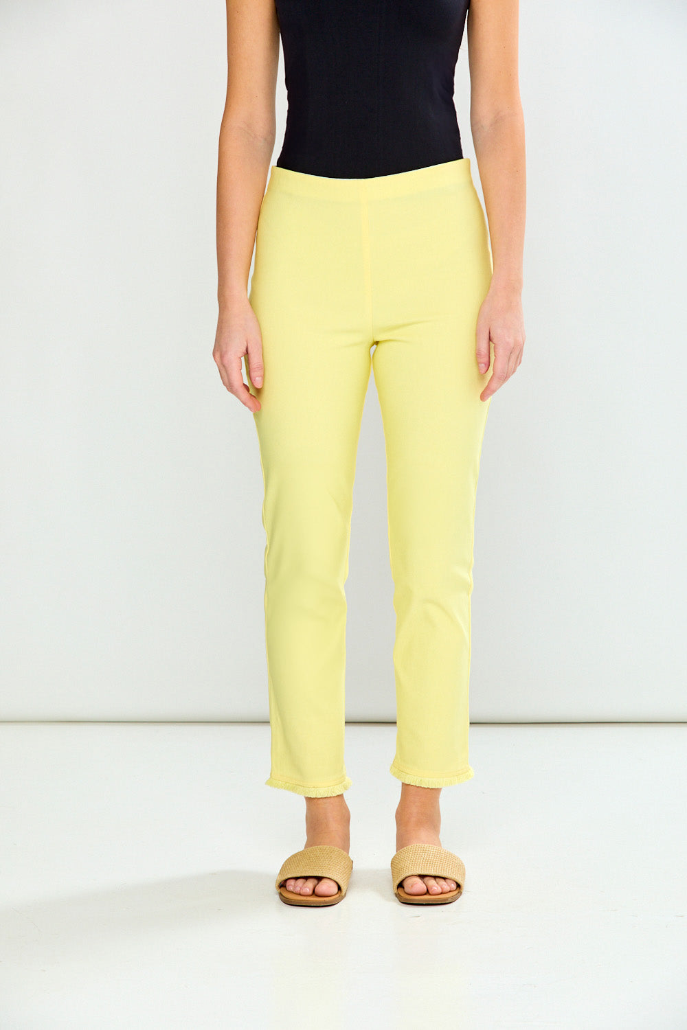 Person wearing yellow pants and a black top on a white background