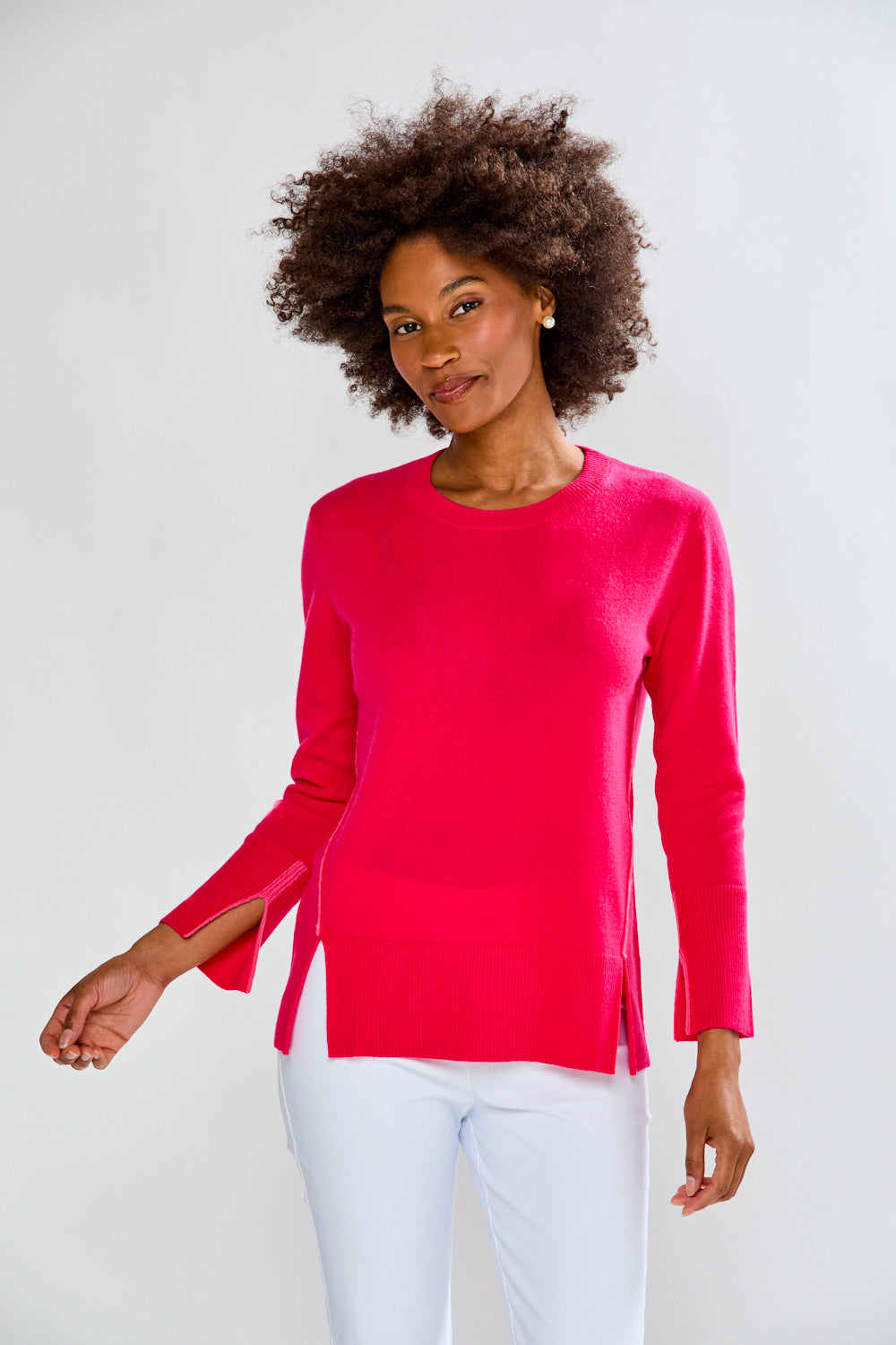 Woman wearing a bright pink long-sleeve top against a white background