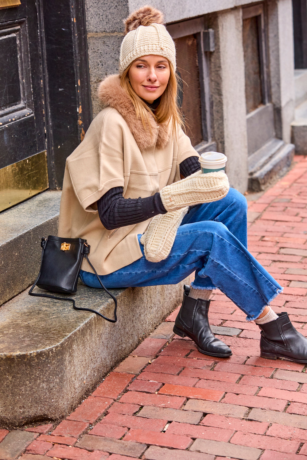 women sitting on steps with coffee in hand