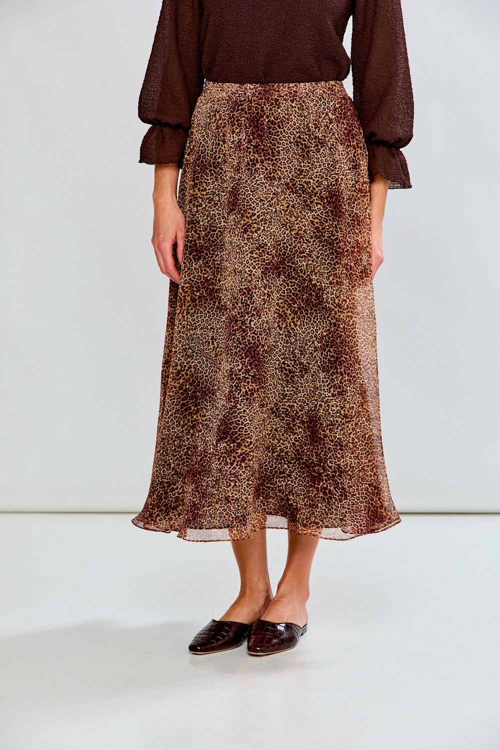 Person wearing a patterned skirt with a plain background