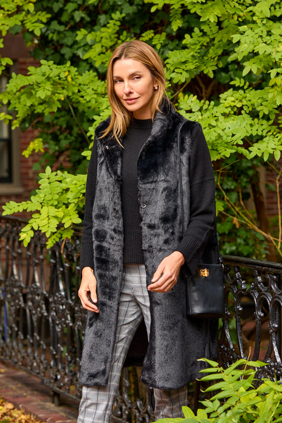 Woman wearing a dark coat with fur trim outdoors