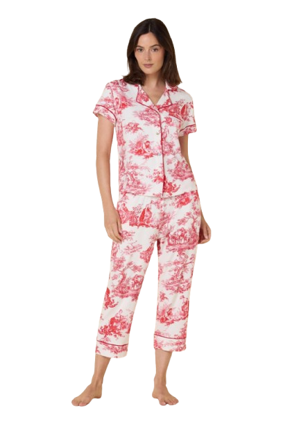 Woman wearing a pink and white toile pajama set on a white background