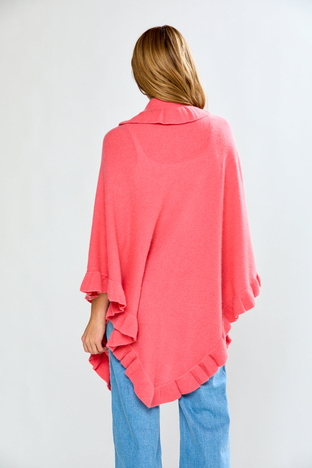 Person wearing a pink poncho over a white background