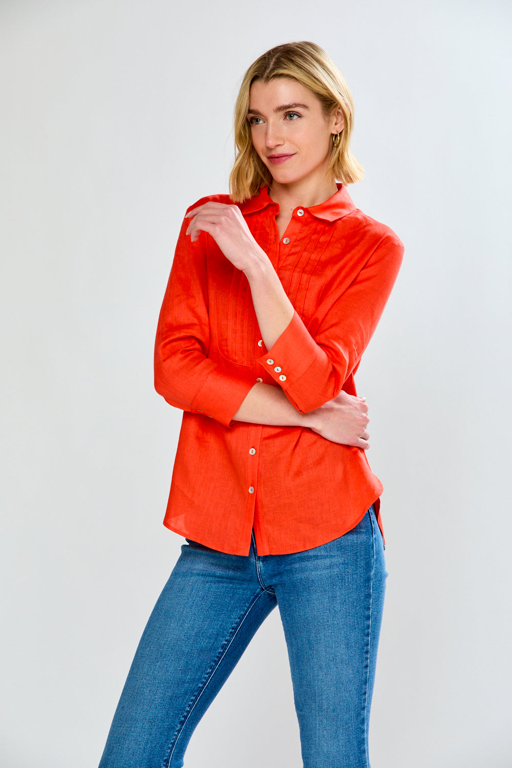 Woman wearing a red shirt and blue jeans on a white background