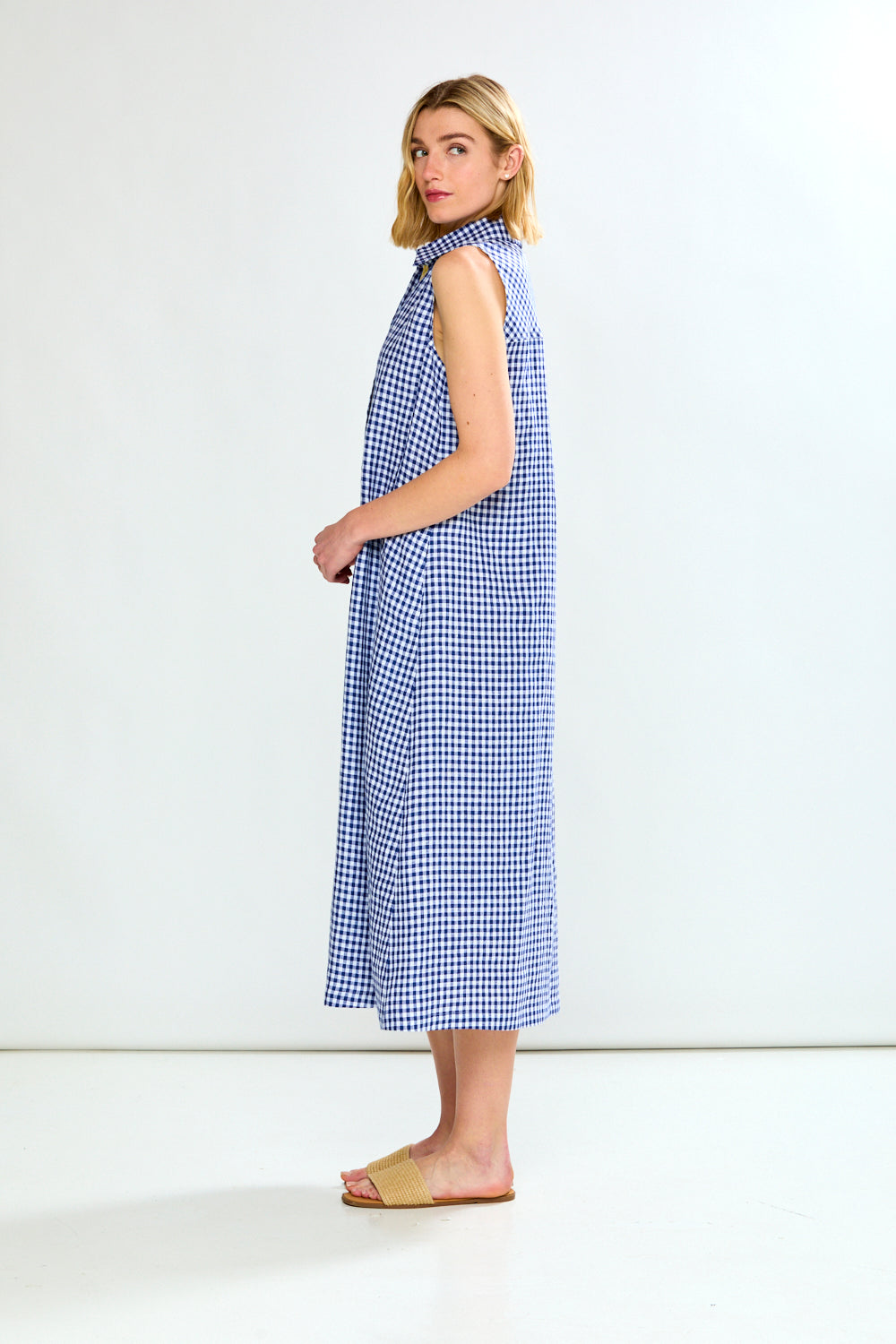 Woman wearing a blue checkered dress against a white background