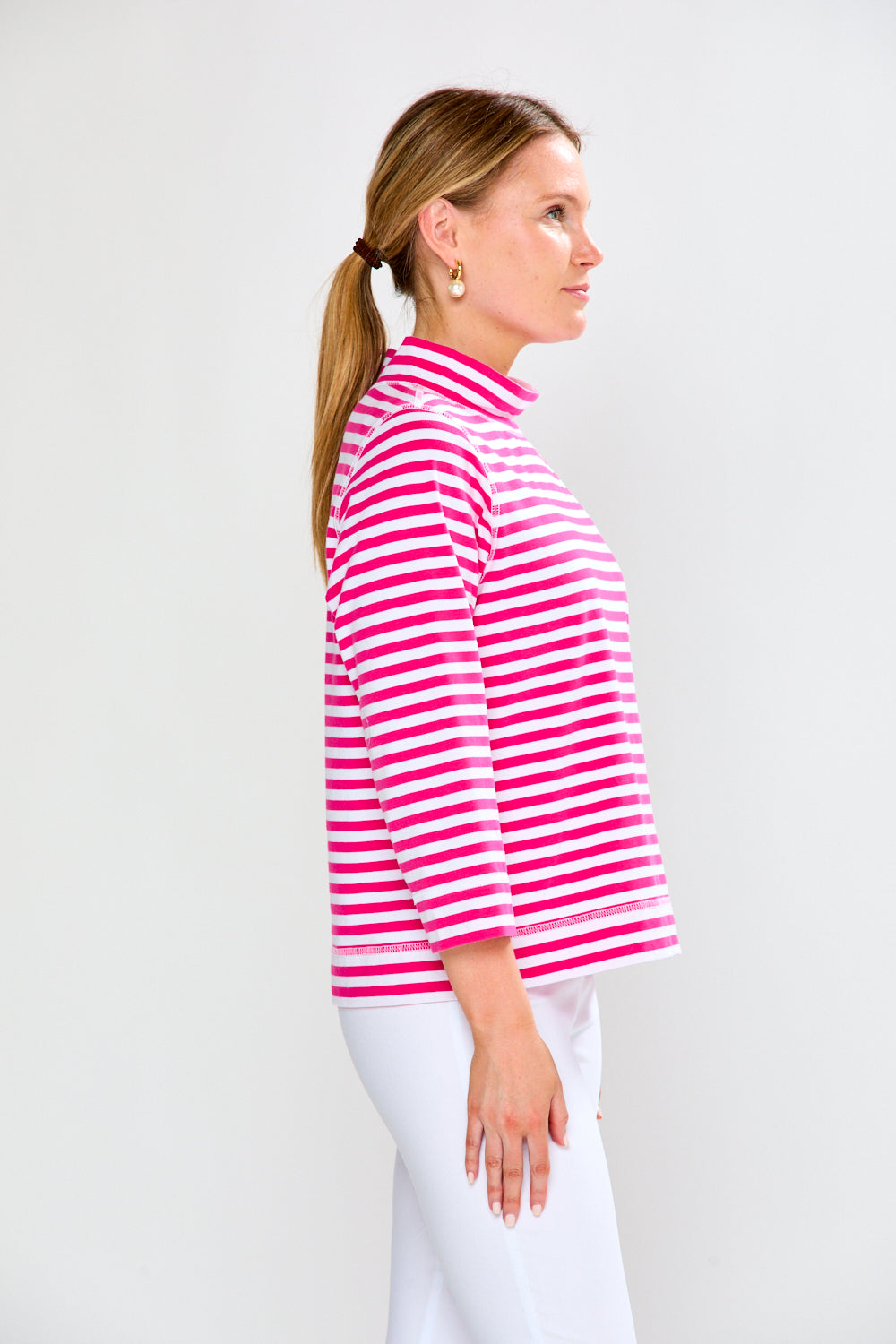 Woman wearing a pink and white striped shirt against a white background