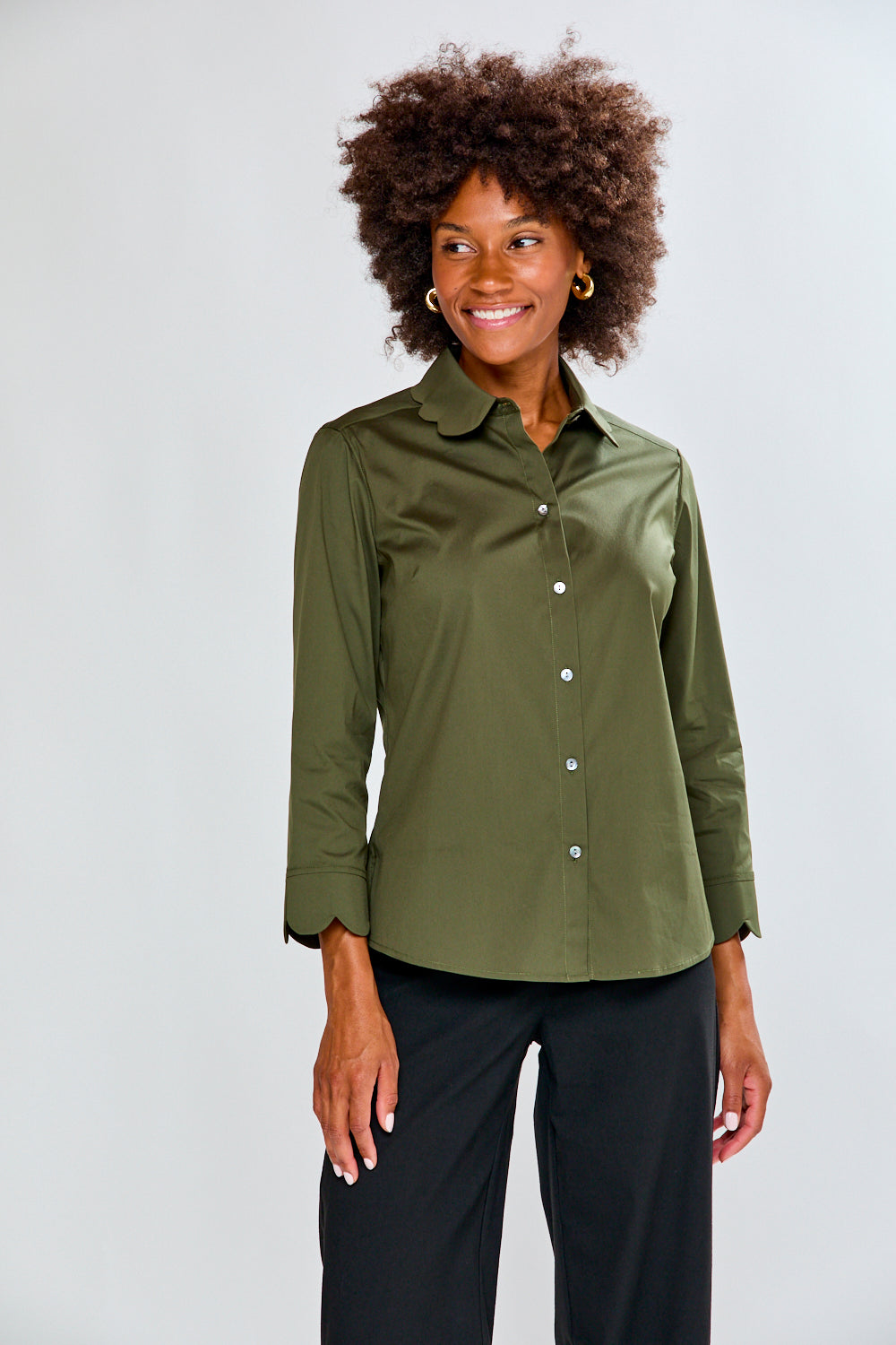 Woman wearing an olive green button-up shirt against a white background
