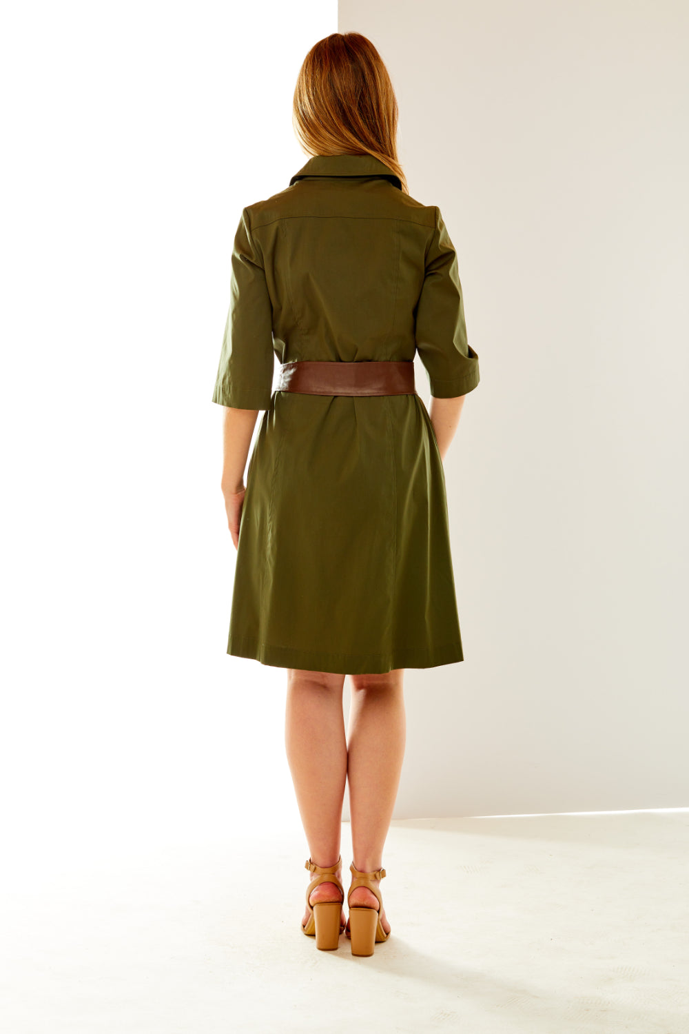 Woman in olive dress with faux leather sash