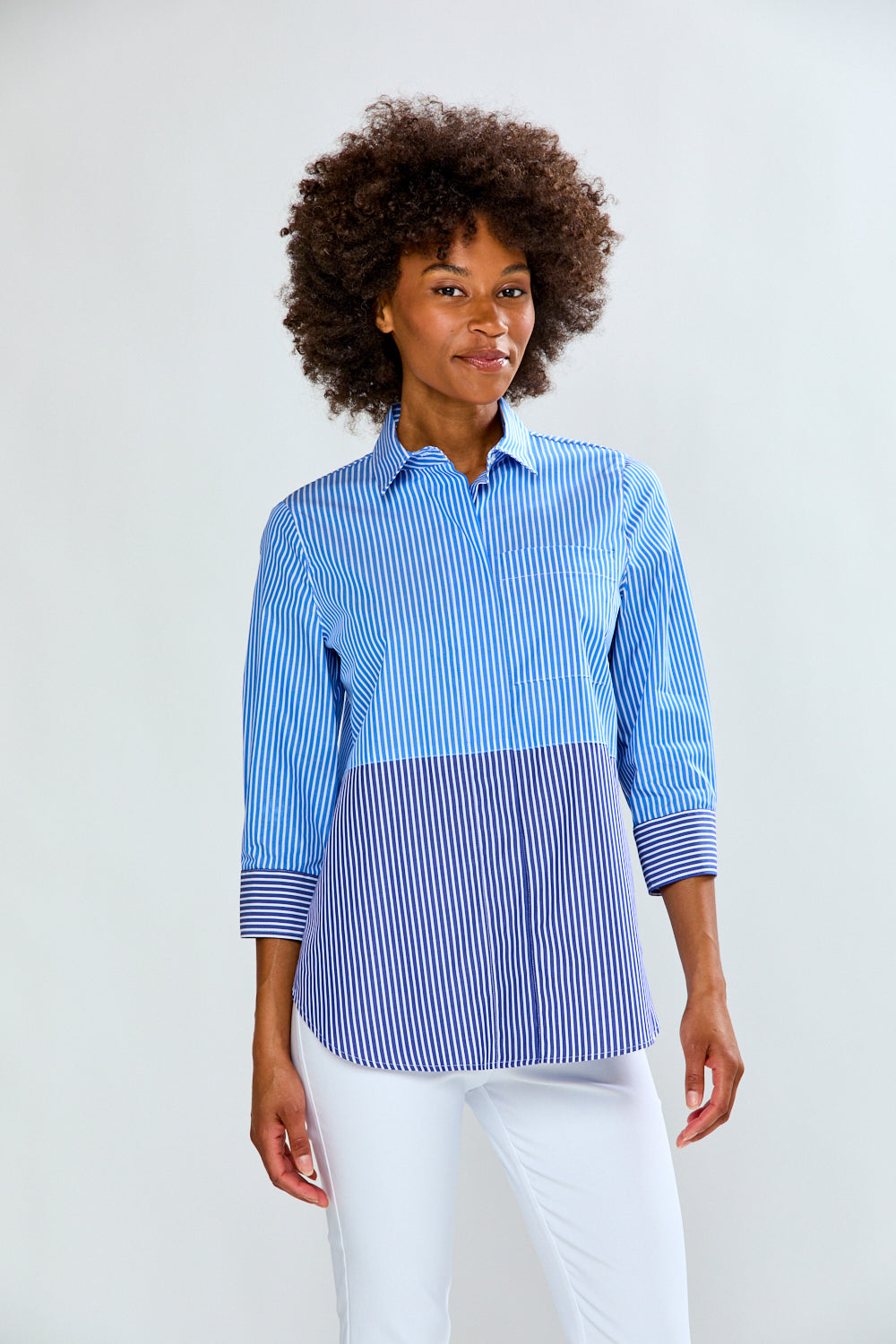 Woman wearing a blue and white striped shirt against a plain background