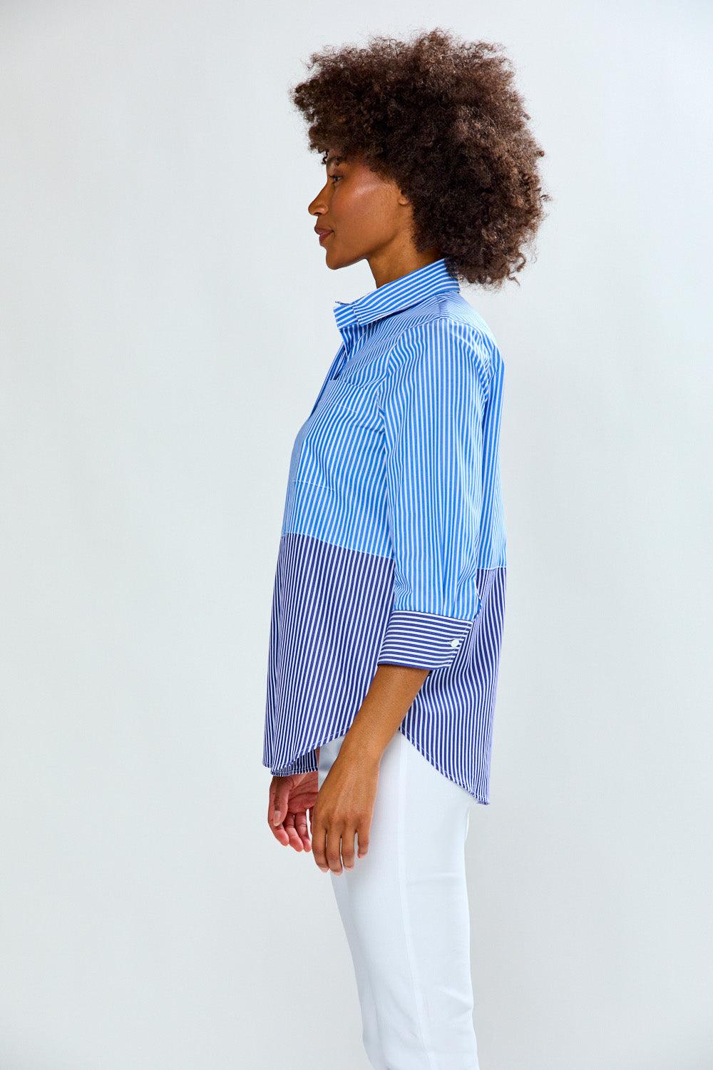 Woman wearing a blue and white striped shirt against a white background