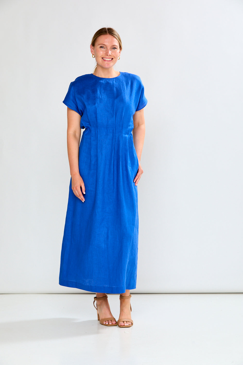 Woman wearing a blue dress against a white background