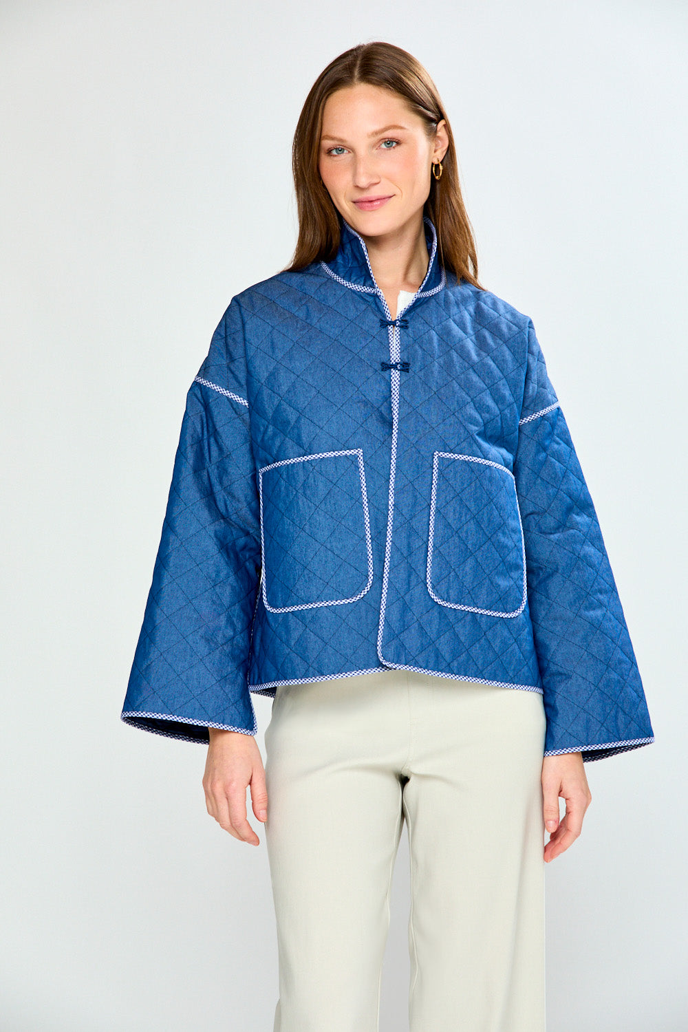 Woman wearing a blue quilted jacket on a white background