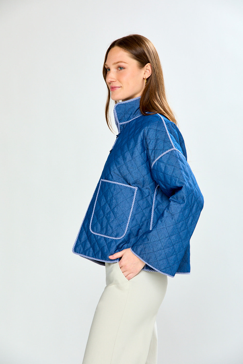 Woman wearing a blue quilted jacket on a white background