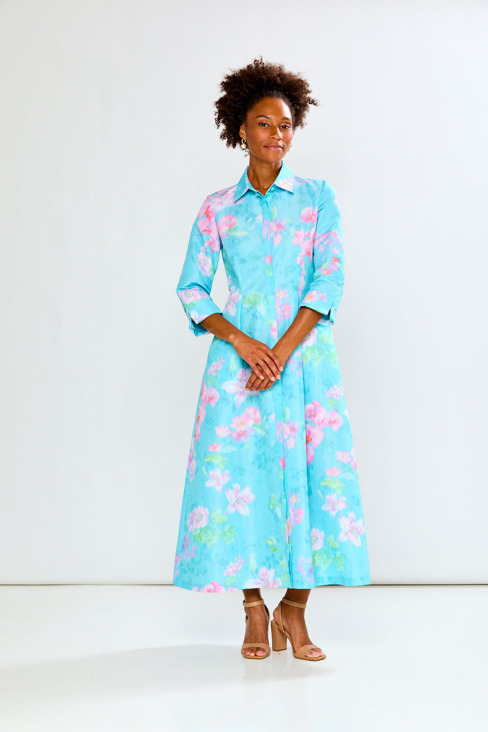Woman wearing a light blue floral dress against a white background