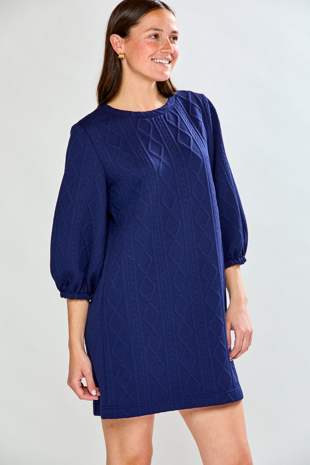 Woman wearing a blue dress with puffed sleeves on a white background