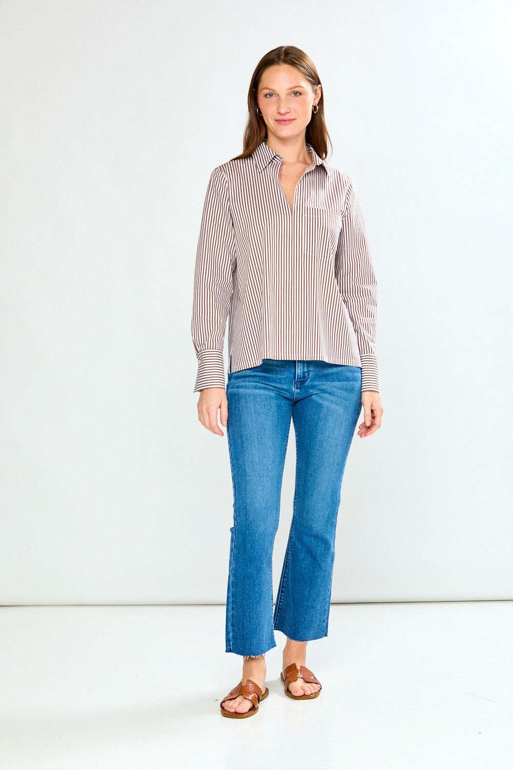 Woman wearing a striped shirt and jeans on a white background