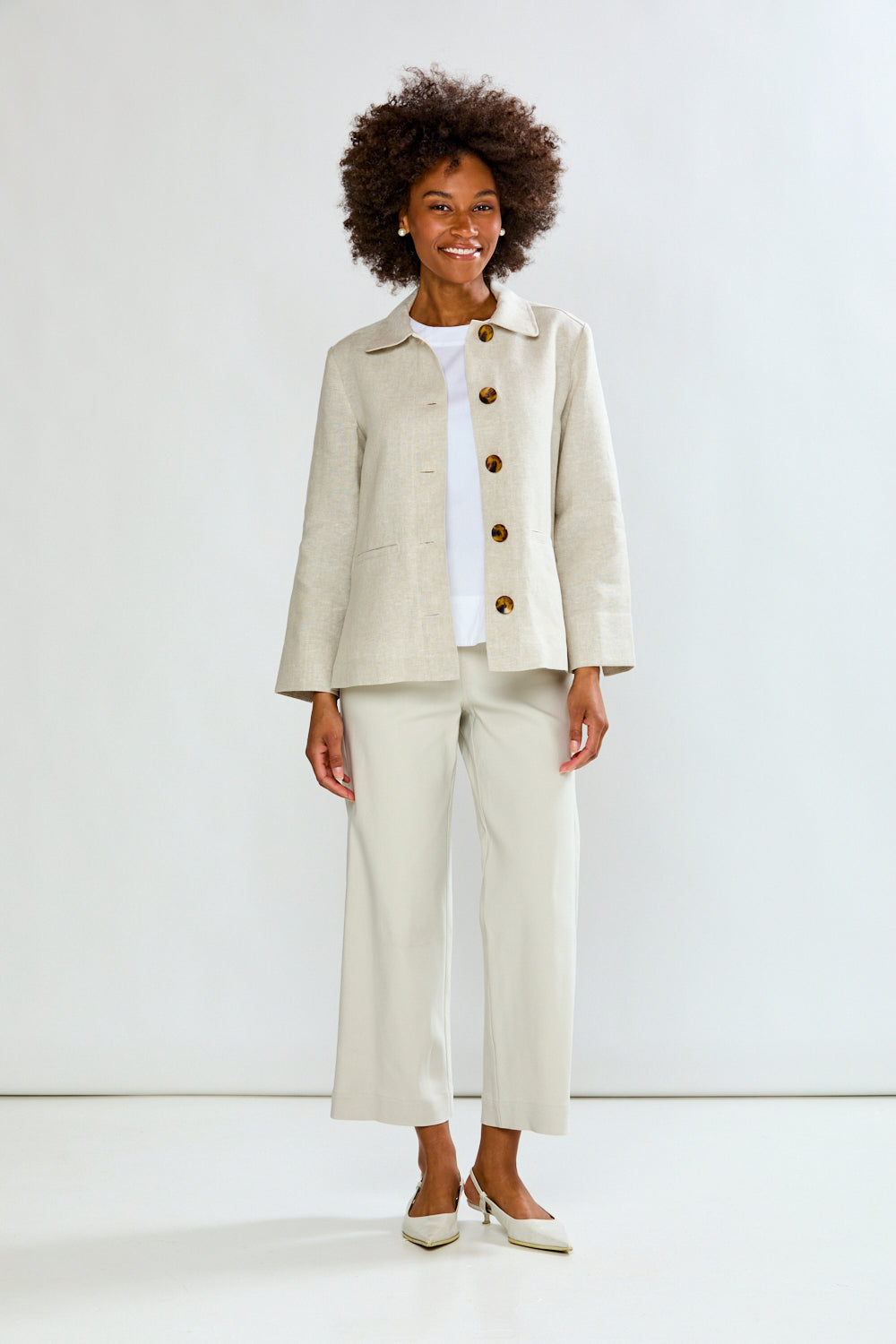 Woman wearing a beige suit with a white shirt on a white background