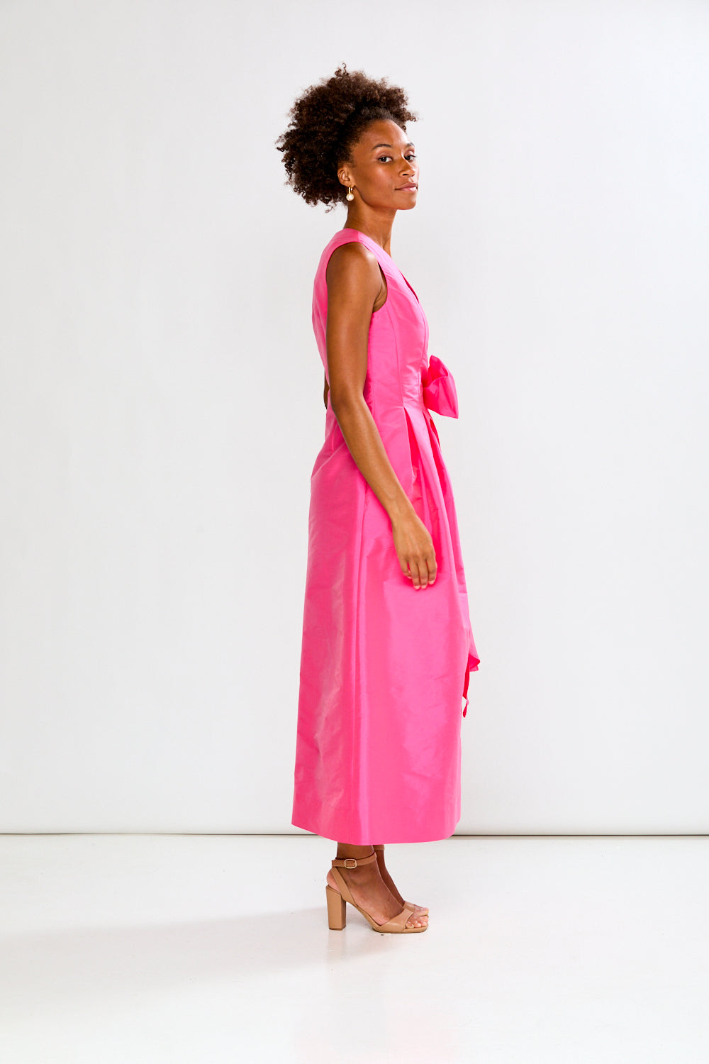 Woman wearing a pink dress with a white background