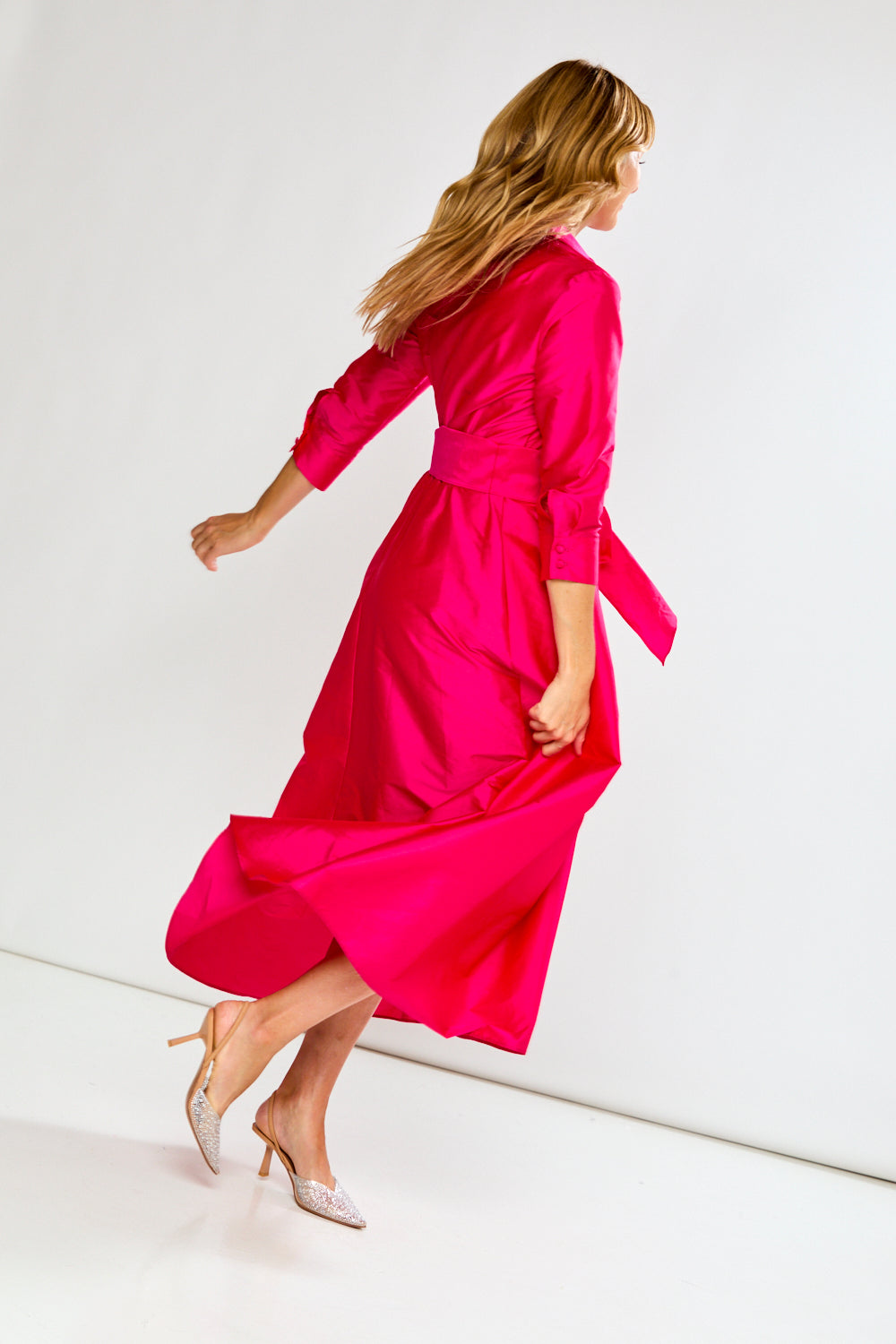 Woman wearing a Fuchsia dress on a white background
