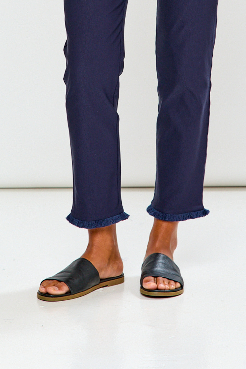 Woman wearing navy blue pants on a white background