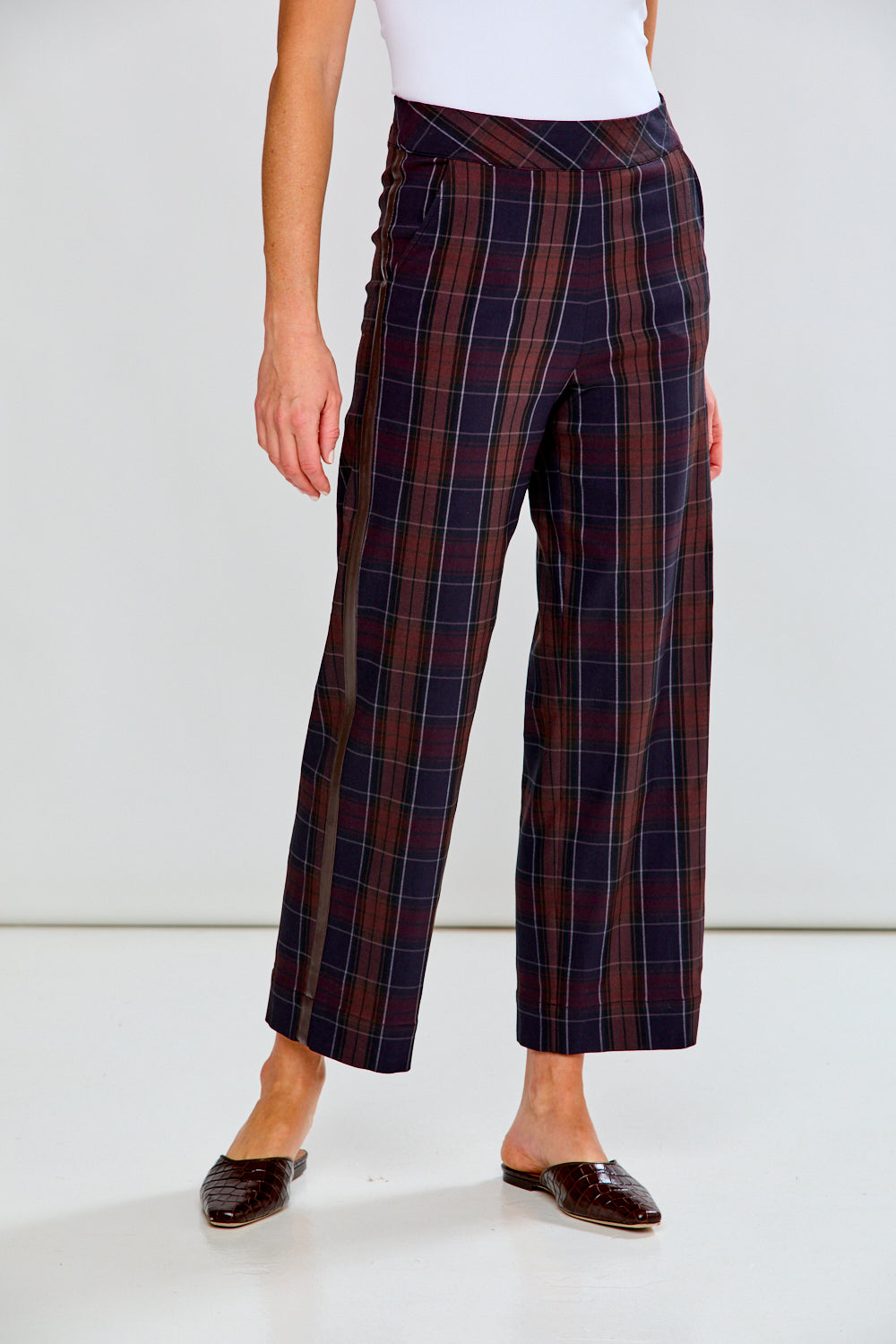 Person wearing plaid pants with a white background