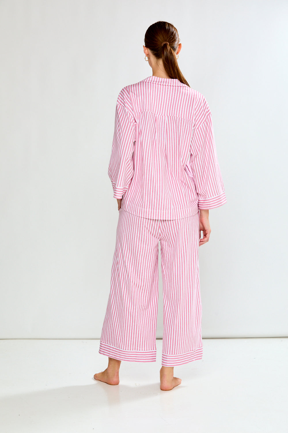 Woman wearing a red and white striped pajama set on a white background