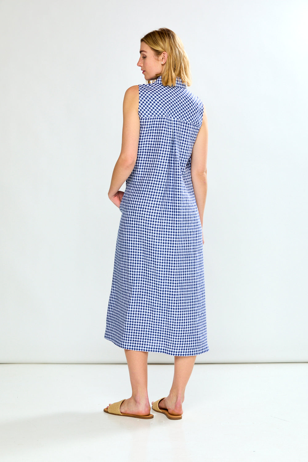 Woman wearing a blue checkered dress against a white background