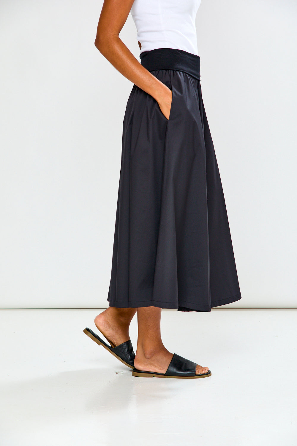 Person wearing a black skirt with a white background