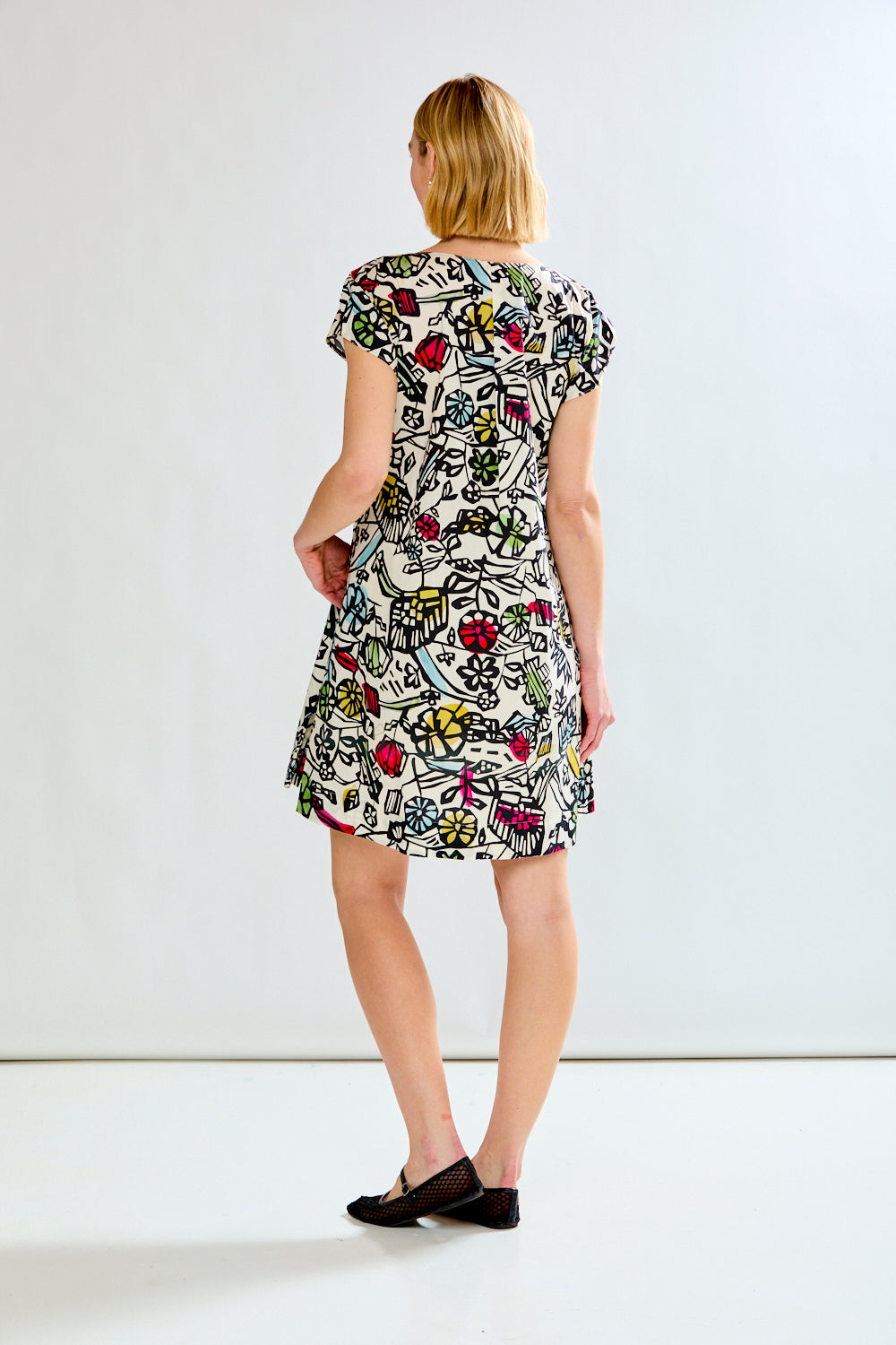 Woman wearing a printed dress on a white background