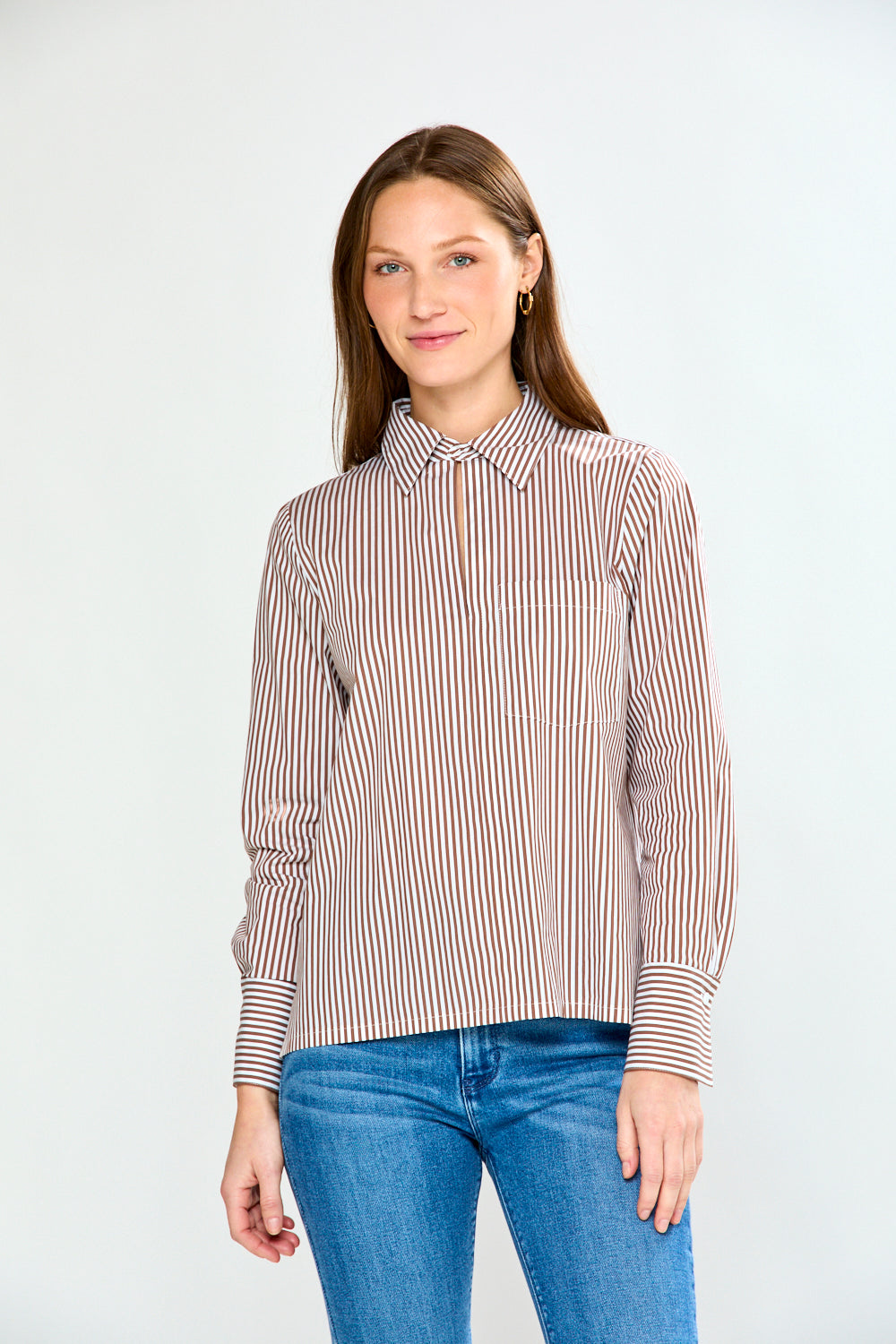 Woman wearing a striped shirt and jeans on a white background