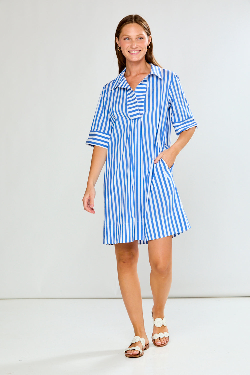 Woman wearing a blue and white striped dress on a white background