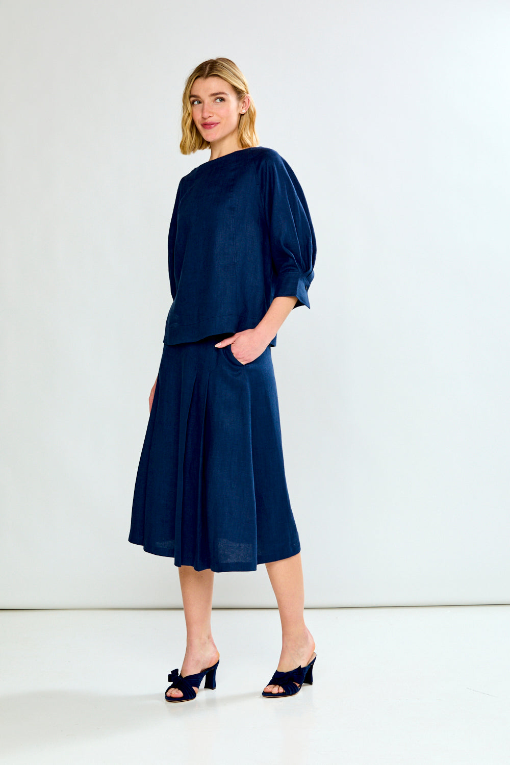 Woman wearing a navy blue outfit with a white background