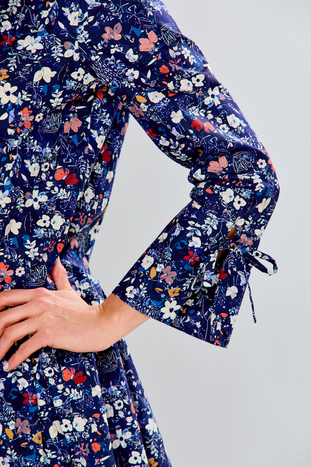 Navy floral dress with long sleeves on a plain background