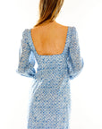 Woman in blue floral long sleeve column dress