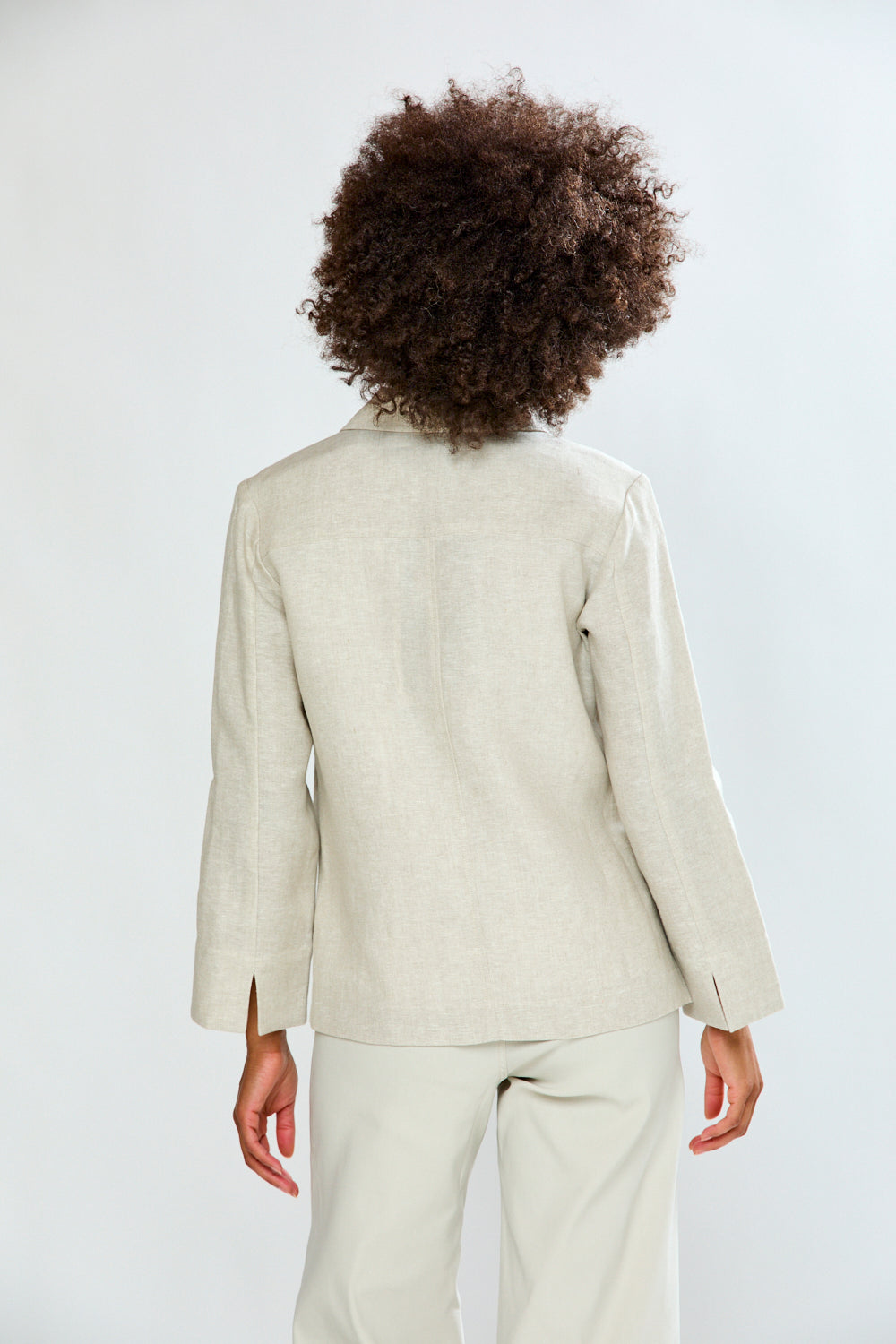 Person wearing a beige suit on a white background