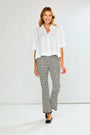 Woman wearing a white blouse and patterned pants on a white background