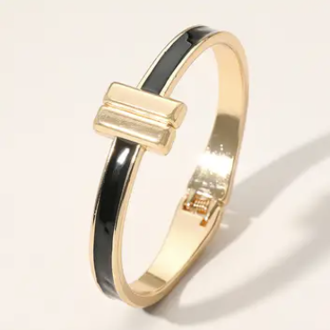 Gold and black bangle on a light gray background