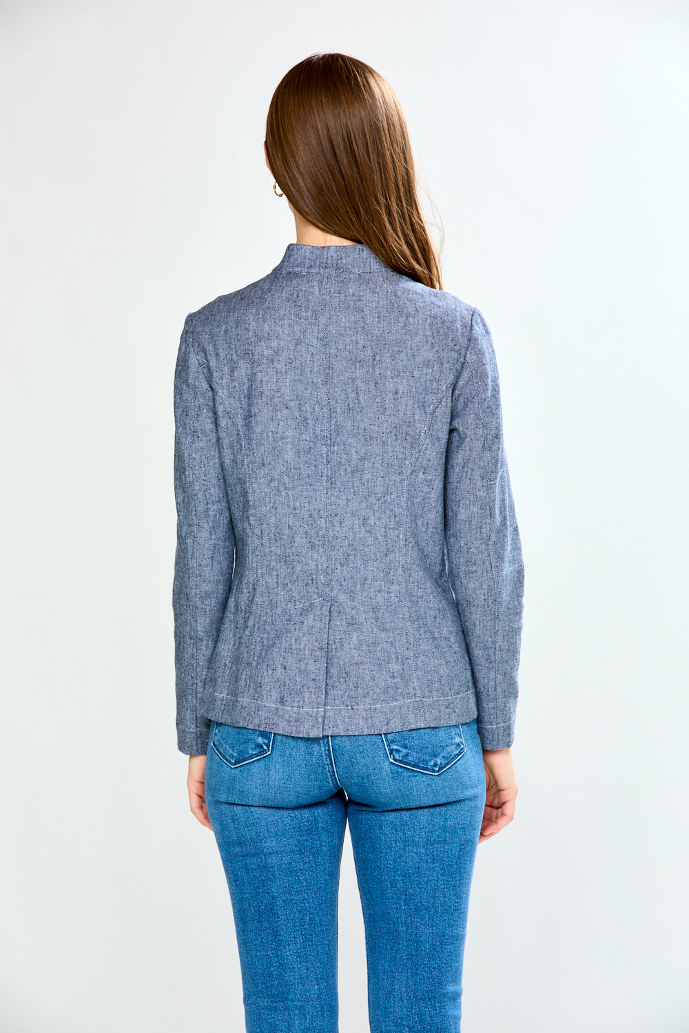 Person wearing a blue checkered blazer and jeans on a white background