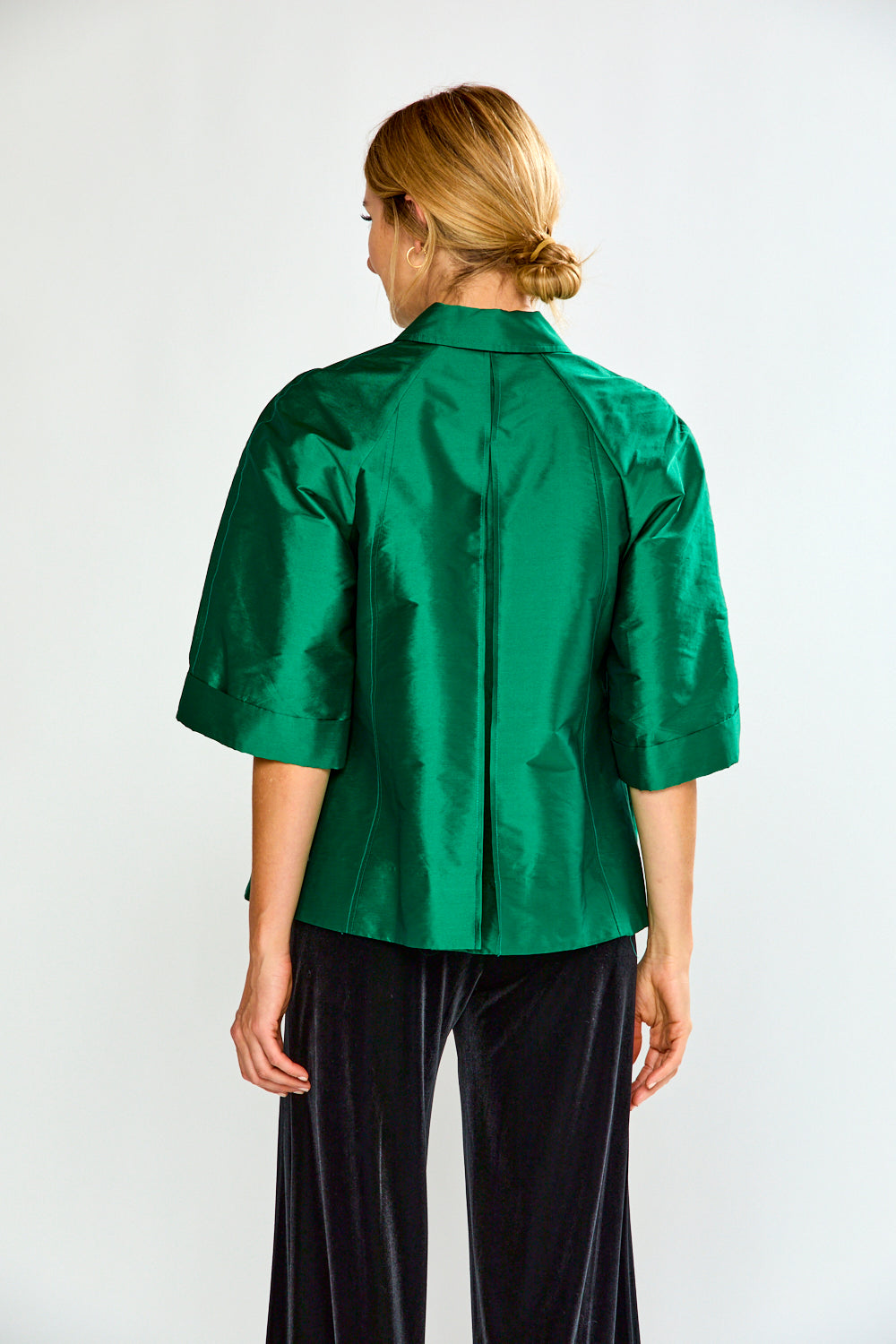 Woman wearing a green shirt with a collar on a white background