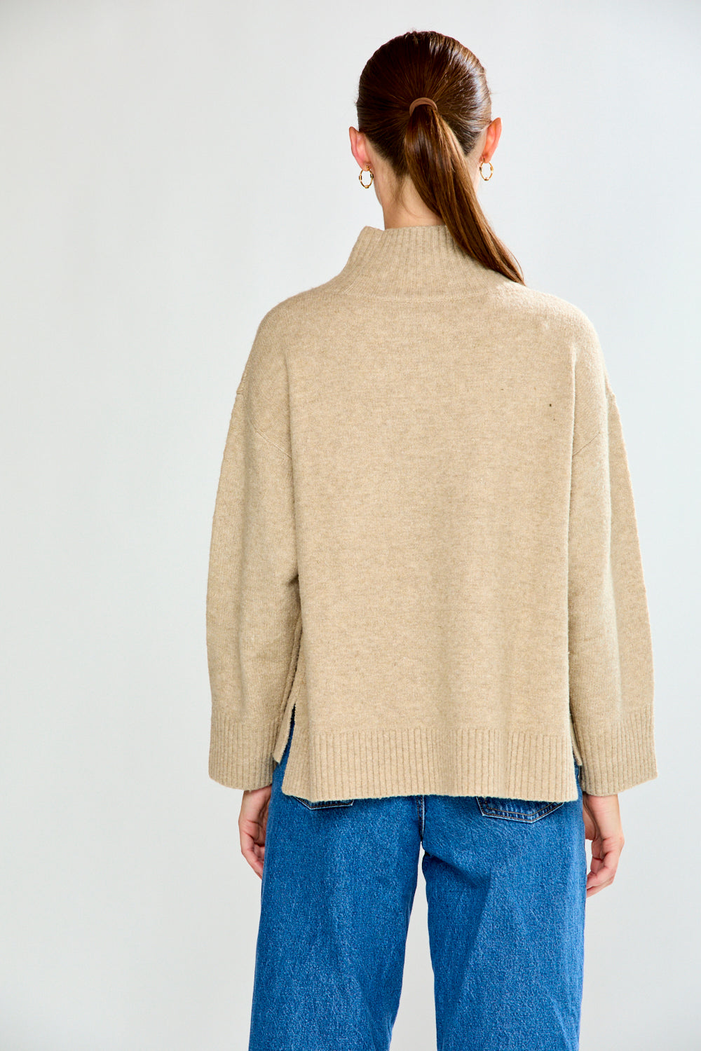 Woman in oat sweater with jeans