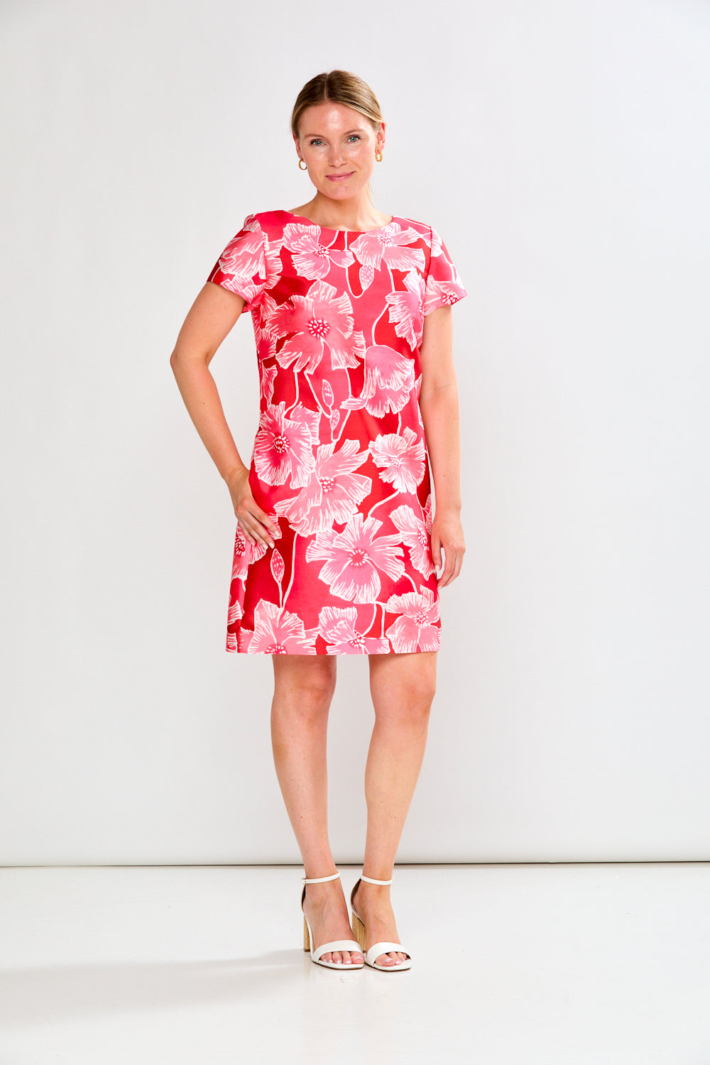 Woman wearing a pink floral dress against a white background
