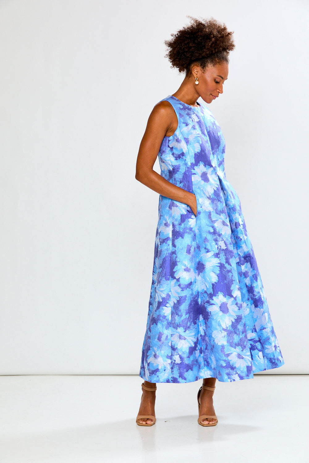 Woman wearing a blue floral dress against a white background