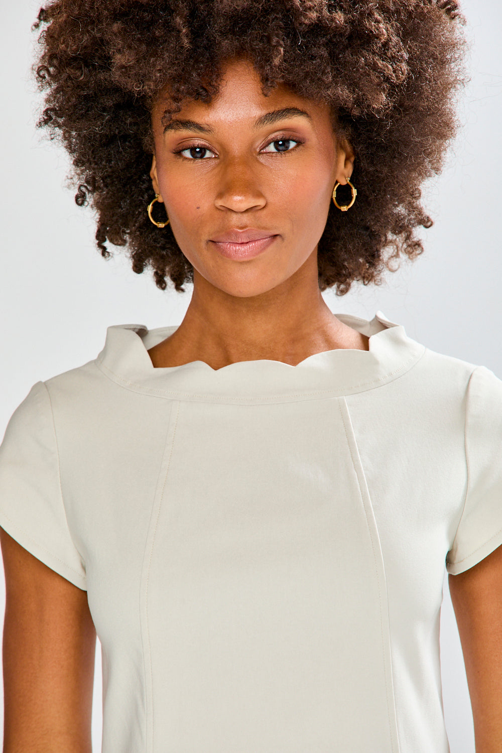 Woman wearing a stone dress against a plain background