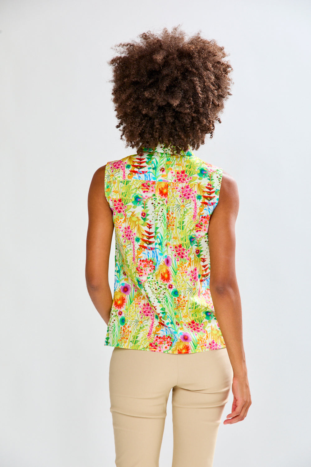 Woman in floral shirt and tan pants 