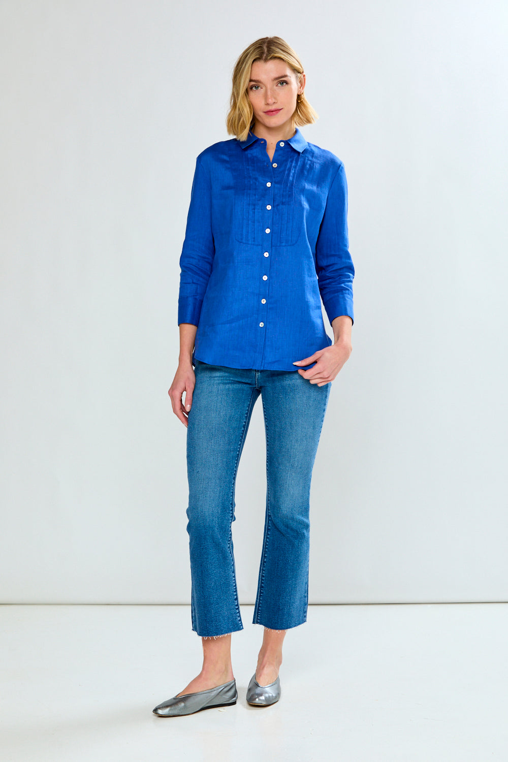 Woman wearing a blue shirt and jeans on a white background