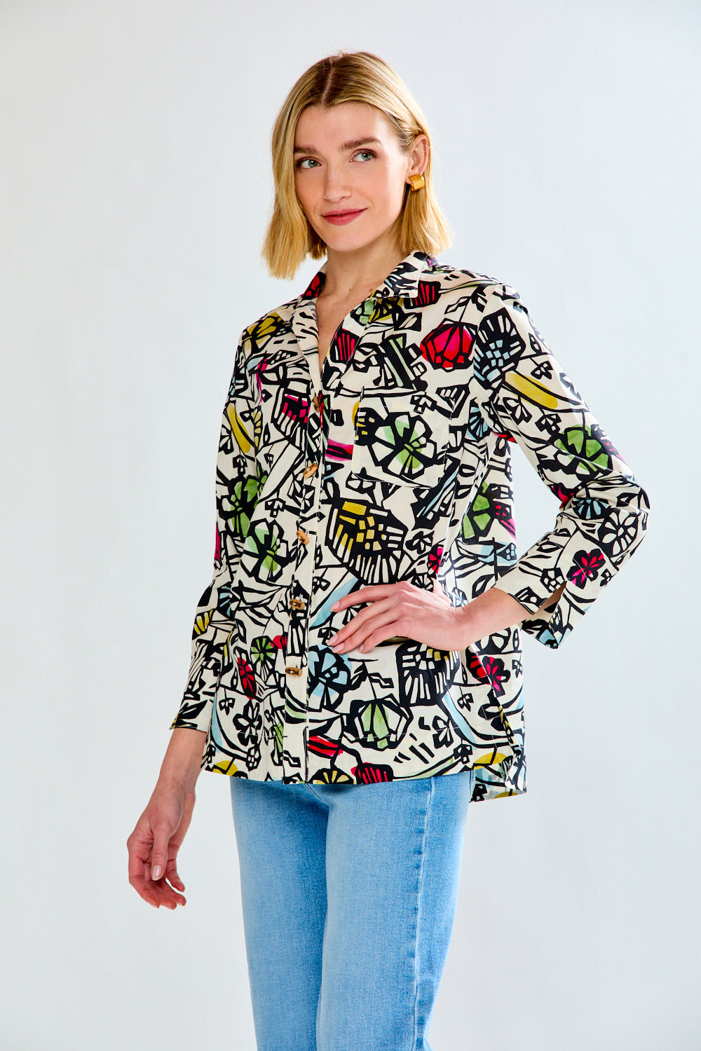 Woman wearing a colorful patterned shirt with a plain background