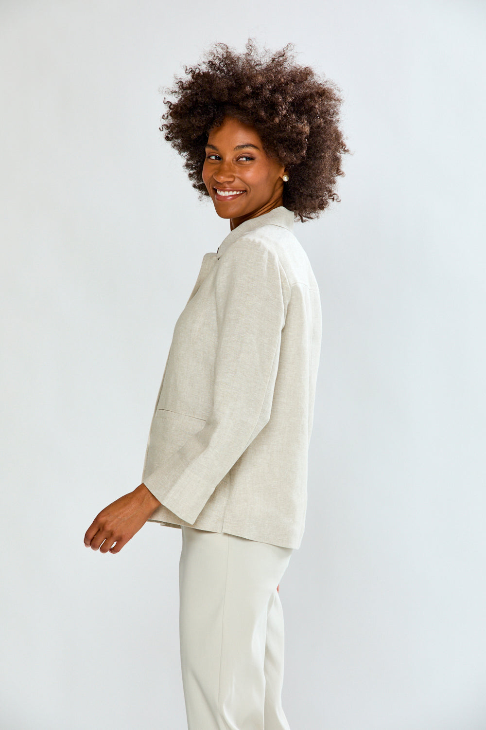 Woman wearing a light-colored suit on a white background